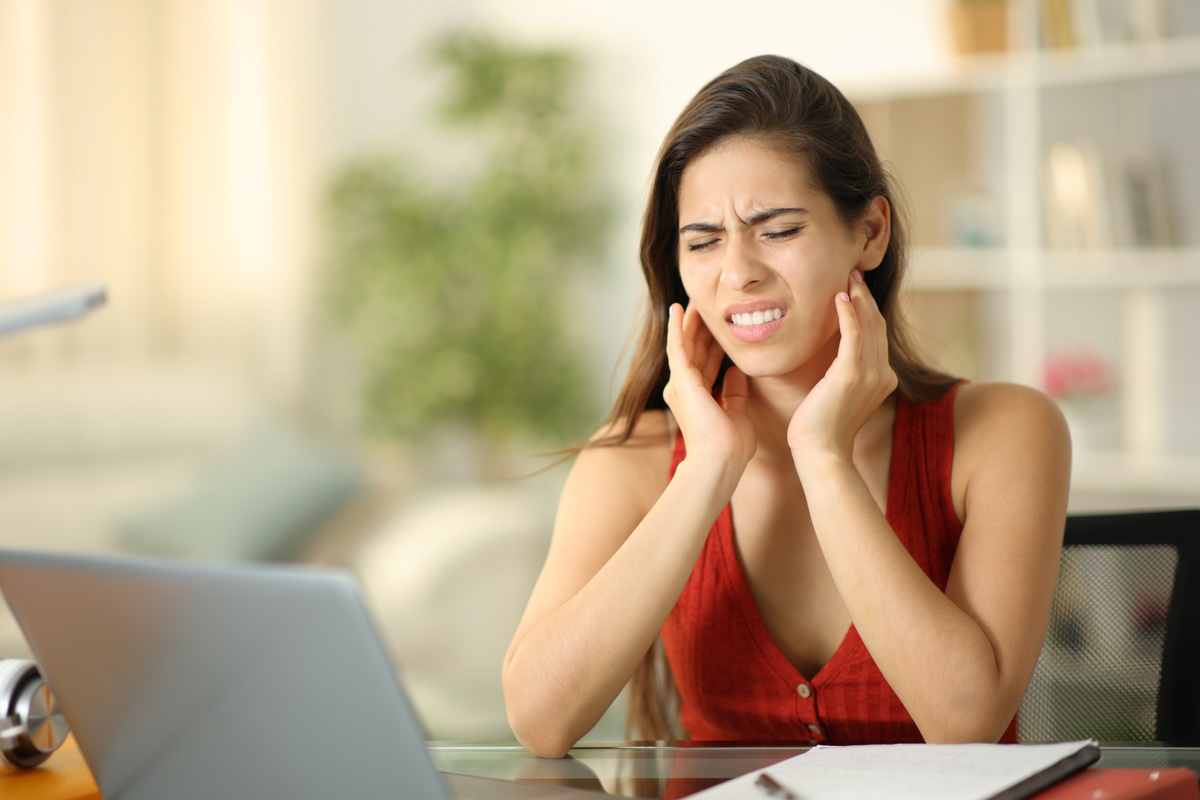 A woman touching her jaw in pain in El Paso.