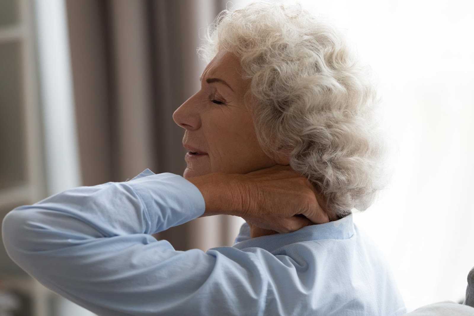 A woman holding her neck in pain